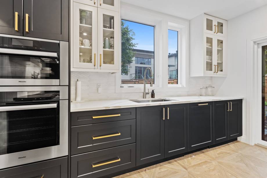 large kitchen with two tone cabinets and glass cabinet doors