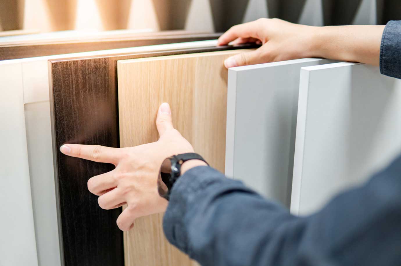 Hands browsing through cabinet materials