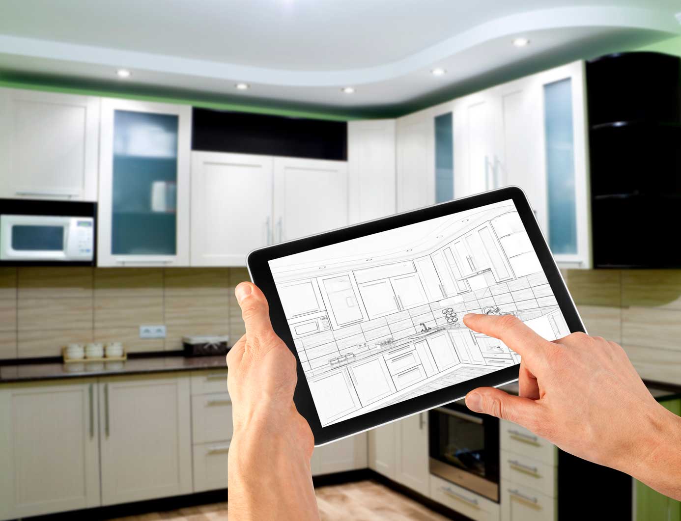 man reviewing designs for kitchen on his tablet